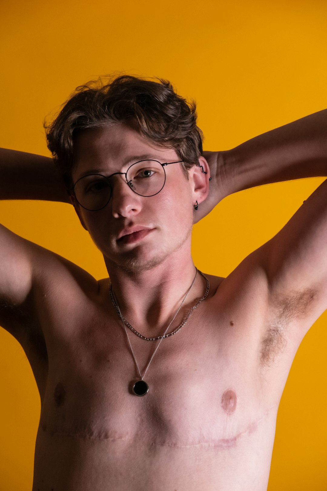 a-shirtless-man-wearing-glasses-and-a-necklace-vrcn1j49vto